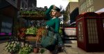 Avatar in a green outfit with a beret posing near flower stand and red phone booth in London City, Second Life.