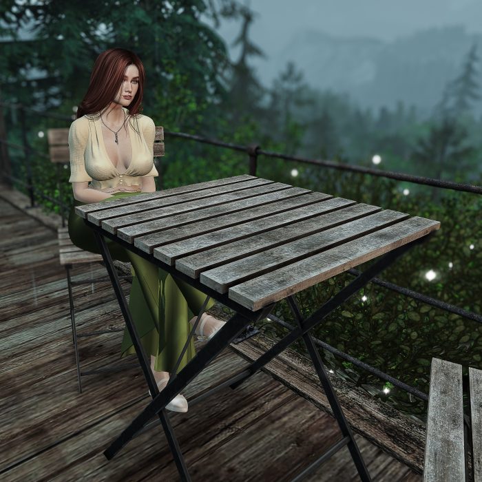 The woman sitting alone at a wet wooden café table, lost in thought