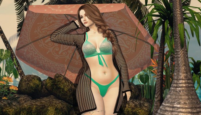 Woman standing in front of the Umbrella, wearing a bikini and a black transparent jacket