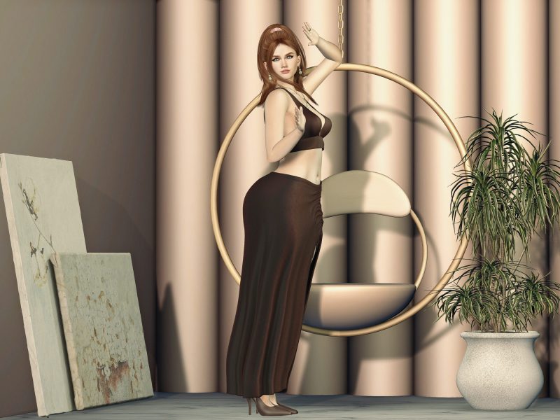 SL fashion avatar posing in a brown crop top and long skirt, one hand on hip and the other raised beside a modern hanging chair.