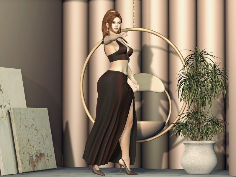 SL fashion model in a brown crop top and slit skirt striking a dynamic pose with arm extended forward beside a hanging chair.