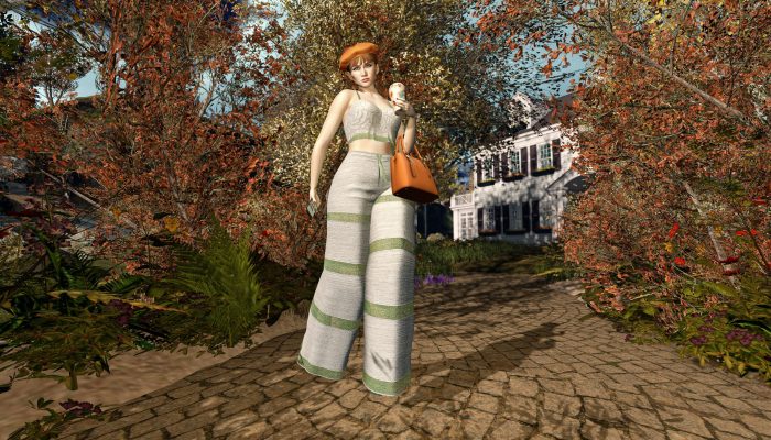 Woman in wide pants and crop top holding a pumpkin spice latte, autumn street background in Second Life.