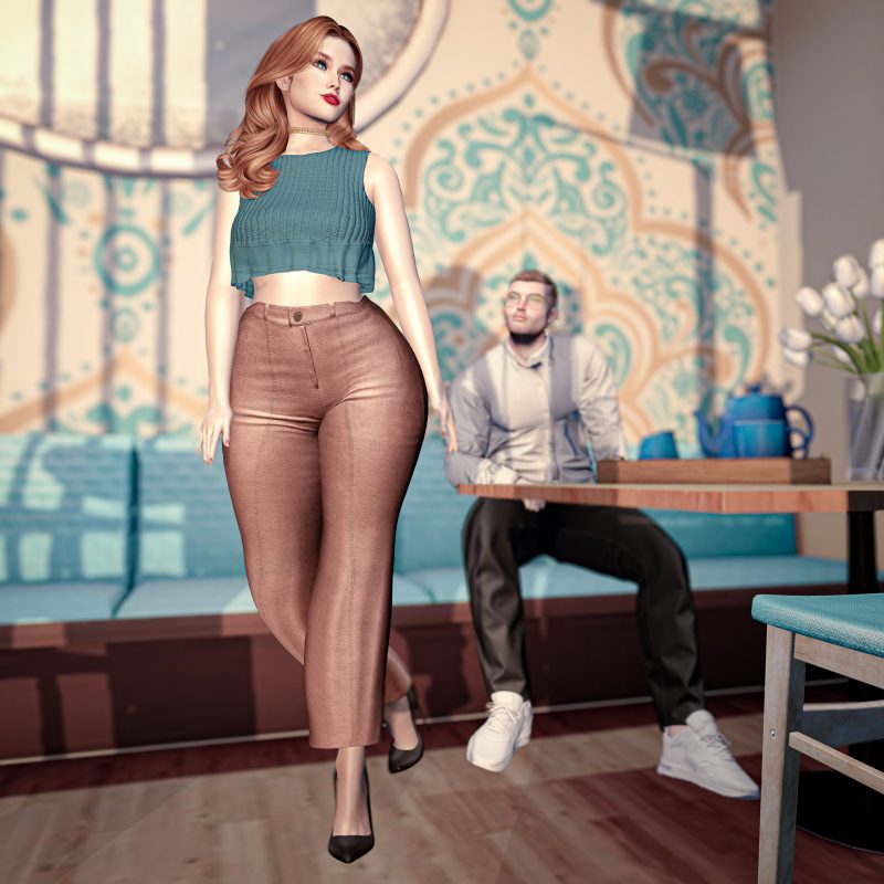 Woman in teal crop top and rose-colored trousers walking past a seated man in a sunlit café, soft romantic lighting.
